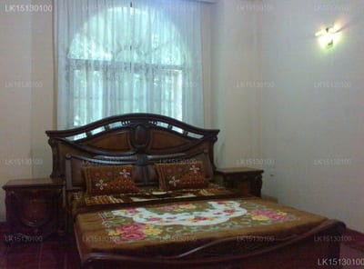 Forest Villa - ornate wooden bed with floral bedspread and arched window