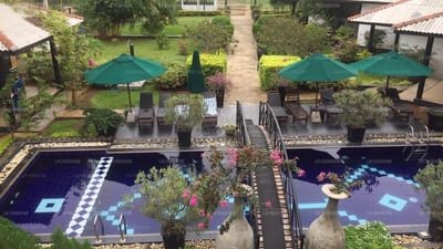 Wapi - two illuminated pools with green umbrellas and garden pathways