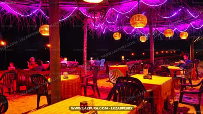 Hotel Blue Note - outdoor dining area with tables lit in yellow and purple neon lighting at night