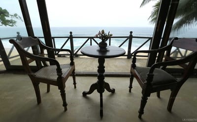 Amor Villa - two wooden chairs facing beach and sea view through railings