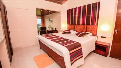 Iris Villa - two double beds with burgundy striped runners in warm-toned bedroom