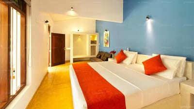 Fantasea - hotel bedroom with blue accent wall, white bed, and orange runner