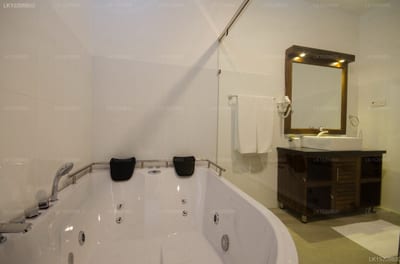 Okwin Resort - Bathroom with whirlpool tub and dark wood vanity with mirror