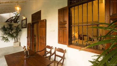 Ceylon Olive - colonial-era interior with wooden doors and woven chairs