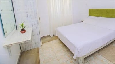 Una J Villa - bright bedroom with white bed, small potted plant and window