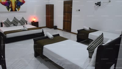 Vimanra - spacious bedroom with multiple twin beds and dark wooden doors