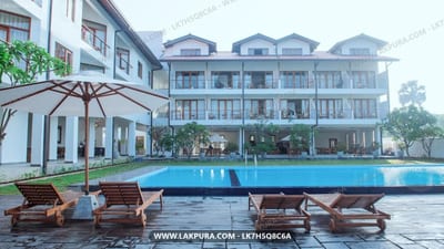 Cardamon Hotel - poolside loungers facing large hotel building with blue swimming pool