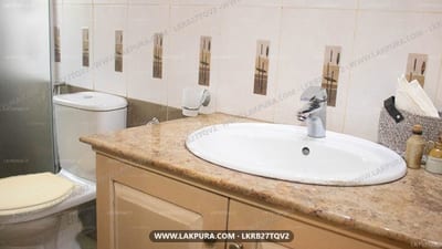 Kandy Riverside Villa - bathroom with dual white sinks, wooden vanity and tiled walls