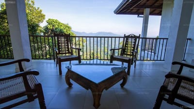 Jack Tree Lodge - covered terrace with seating overlooking ocean and forested coastline