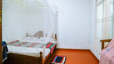 Sagopearl Guest - simple bedroom with wooden bed and orange floor
