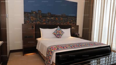 Sofia Colombo City Hotel - hotel bedroom with city skyline artwork above bed