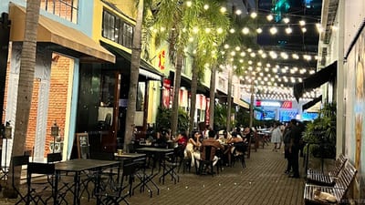 Monsoon - evening street market with illuminated canopy, shops and dining crowds