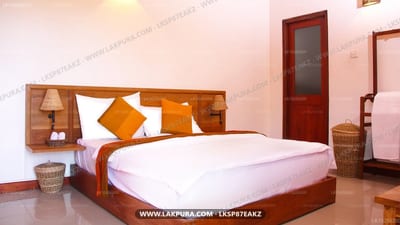 Elephant Villa - wooden bed with orange pillows in bright room