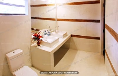 Hotel Suite Lanka - modern bathroom with white square sink, toilet, and red flower decoration