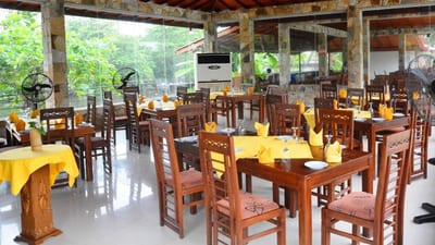 River View Hotel - open-air dining area with wooden tables and chairs overlooking greenery
