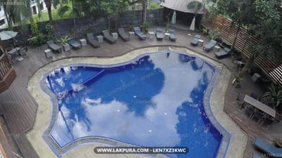 Hotel Sunray - overhead view of curved blue pool with loungers and surrounding deck