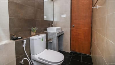 Java Moon - compact bathroom with toilet, sink, mirror and tiled walls