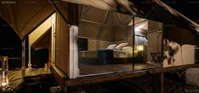 Kodev - glamping tent interior with bed and lighting at night