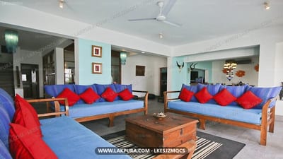 Footprints - spacious lounge with blue sofas, red cushions, and wooden furniture