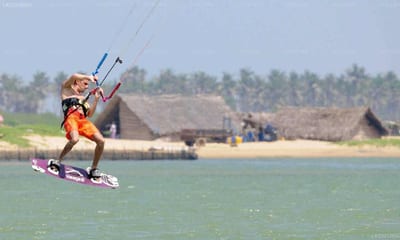 Kodev - kite surfer in yellow jacket on turquoise water