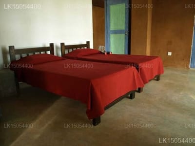 Wapi - two beds with red covers in simple room