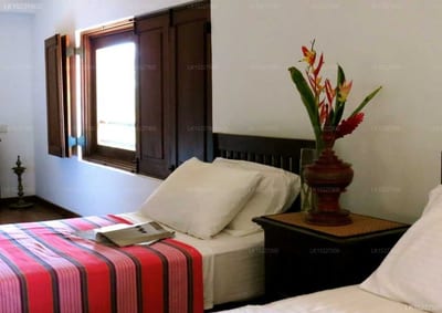3 سيسترز بيتش هاوس، ماتارا - bedroom with twin beds, striped blanket, and tropical flowers on nightstand