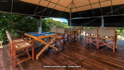 Kodev - wooden dining tables and benches under covered pavilion with forest view
