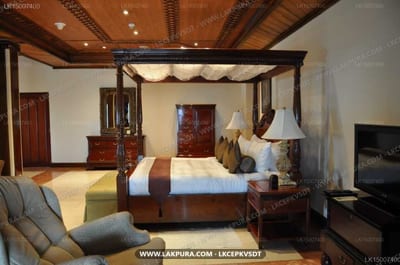Earl's Regency - spacious bedroom with four-poster bed, wooden furnishings, and cream canopy