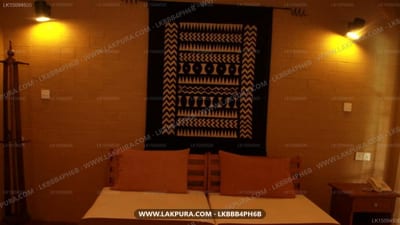 Bopath Fall Rock Chalets - cozy bedroom with geometric wall tapestry and warm lighting