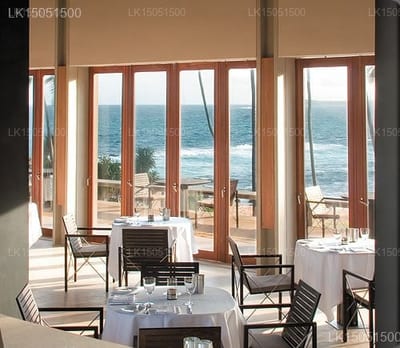 Amanwella - elegant dining room with ocean views through floor-to-ceiling glass doors