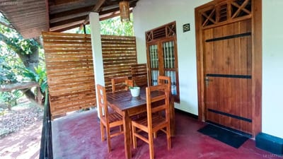 Wild Heavan - wooden dining table and chairs in open-air lodge room