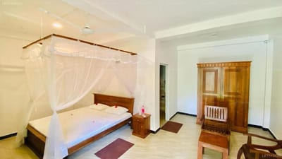 Chandra Villa - spacious bedroom with four-poster bed, white canopy, and wooden wardrobe