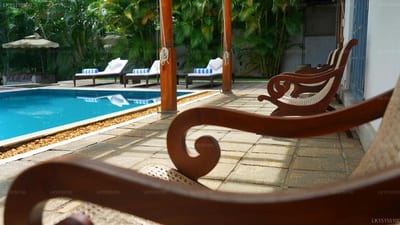 Apsara Villa - wooden loungers on terrace overlooking blue swimming pool