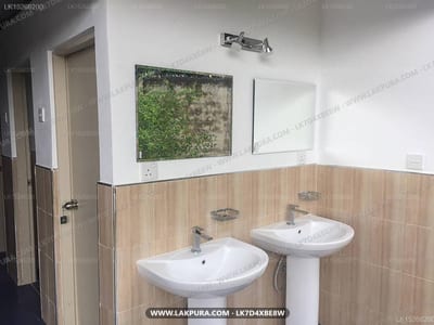 Green Grass Hostel - bathroom with two pedestal sinks and wooden wall paneling