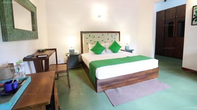 Muthu Villa Kandy - bedroom with green accents, wooden furniture and desk area