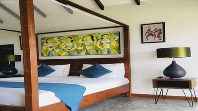 Elephant Stables - four-poster bed with blue bedding and wooden headboard art