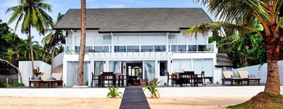Casa Mija - beachfront house with palm trees and sandy beach in front