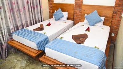 peacock eco resort - twin beds with blue pillows and blankets in brick room