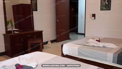 Arangala Bungalow - spacious twin bedroom with wooden furniture and entrance door