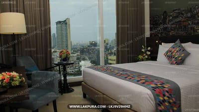 Sofia Colombo City Hotel - bedroom with city skyline view through tall windows