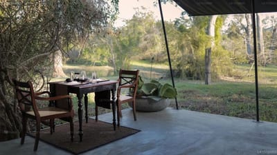 Leopard Trails - dining table and chairs on shaded terrace overlooking savanna landscape