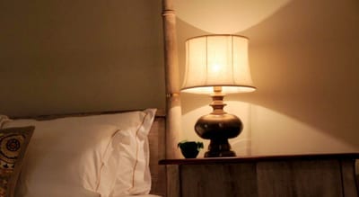 W15 - bedside lamp illuminating intimate hotel room corner at night