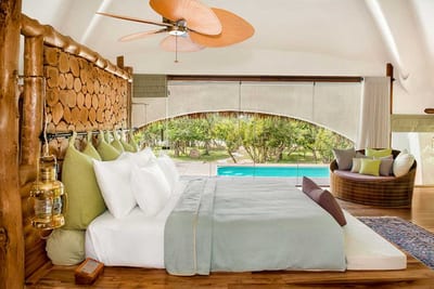 Uga Chena Huts - bedroom with pool view through large curved window