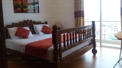 See View Apartment - wooden bed with red bedspread, floor-to-ceiling windows overlooking city