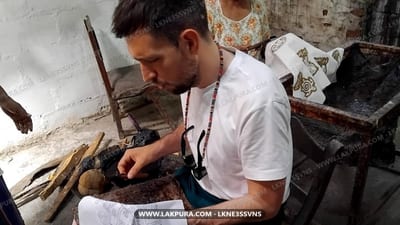 Zážitek batiky z města Kandy - man hand-painting traditional batik design on fabric with wax-resist tool