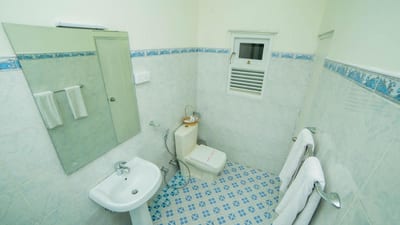 Range kandy - bathroom with sink, toilet, shower enclosure and blue tiled floor