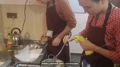 Cooking Experience from Ella City - Two people cooking together in a kitchen, one stirring a pot