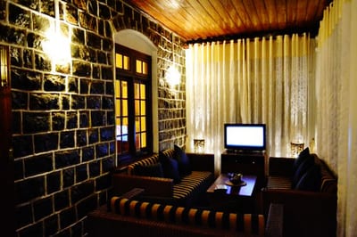 Brockenhurst Nuwaraeliya - dark brick-walled lounge with leather seating and entertainment screen