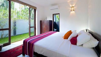 Salt House - bright bedroom with garden view through glass doors
