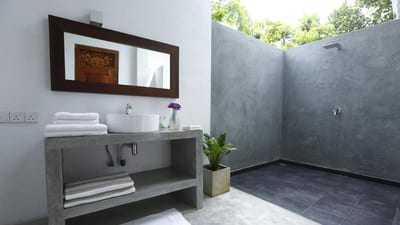 Ceylon Olive - modern bathroom with concrete shower wall and open shelving sink vanity